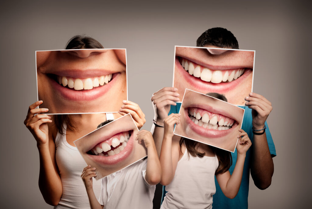 Young Family With Children Holding A Picture Of A Mouth Smiling